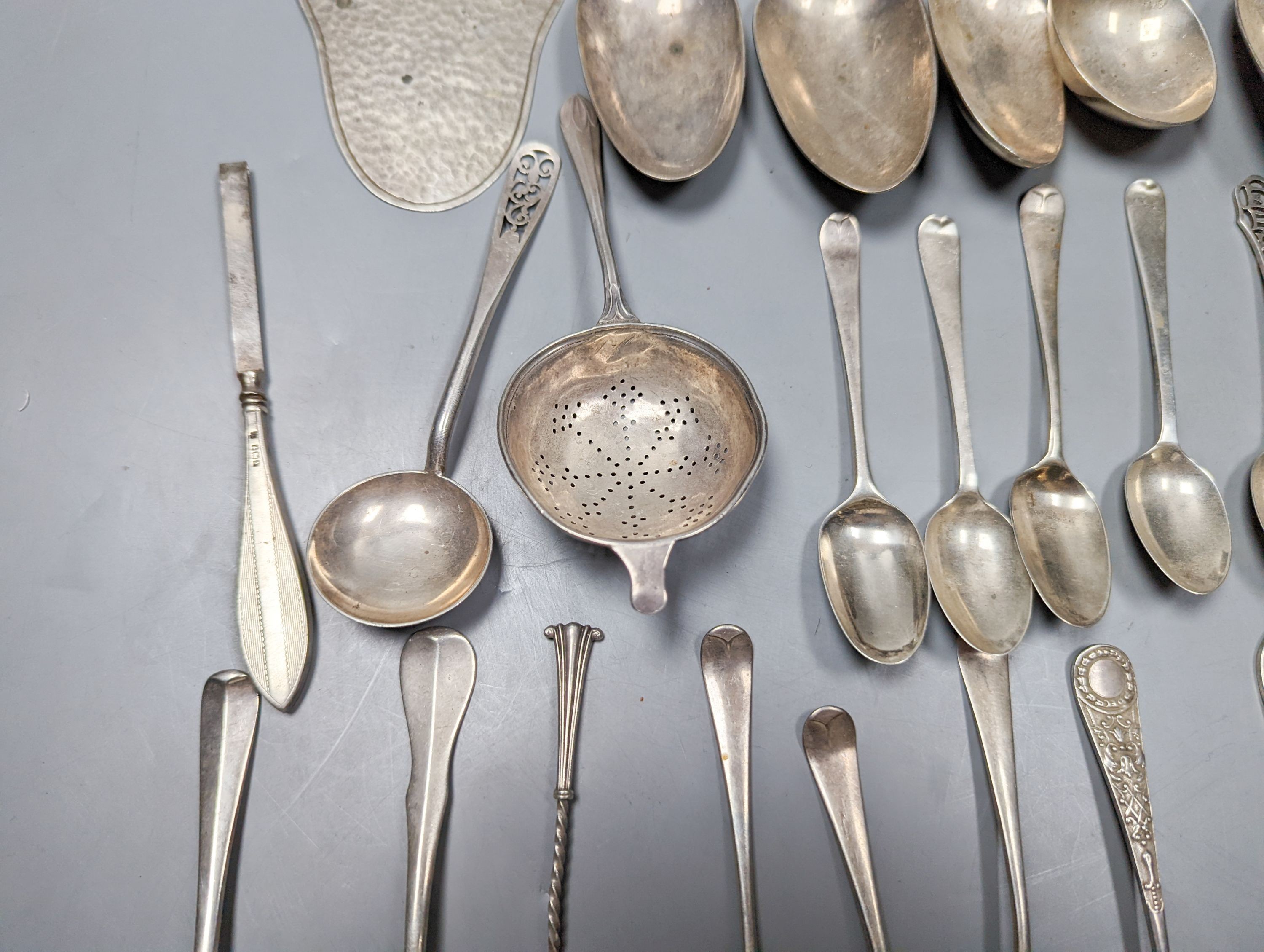 A mixed quantity of 18th, 19th and 20th century silver flatware, including tablespoons, teaspoons, sauce ladles, a 900 standard cake slice, two plated spoons and a nail implement